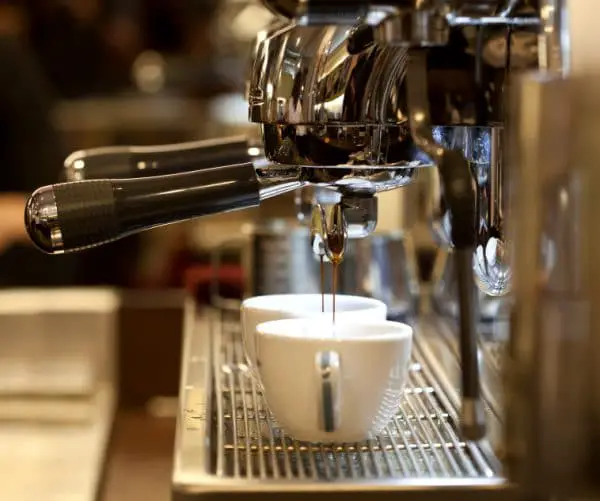 prepares espresso in his coffee shop; close-up